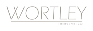 Solid light taupe background with uniform color, no objects visible.